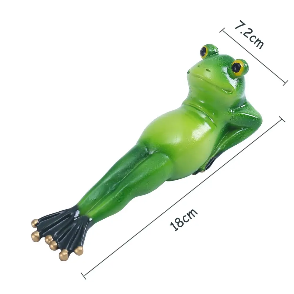 a green frog figurine sitting on top of a table
