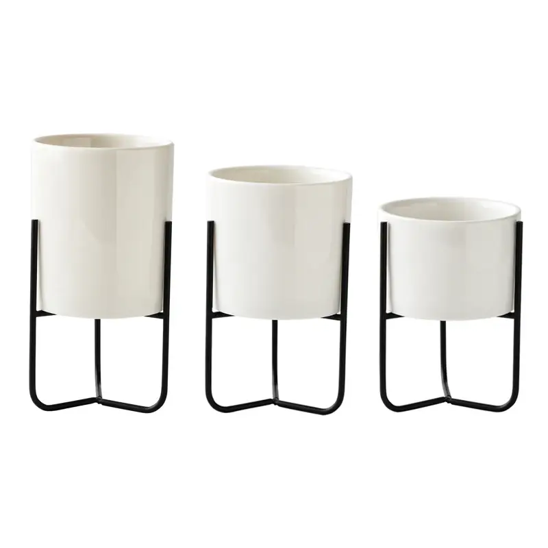 three white planters sitting on top of a metal stand
