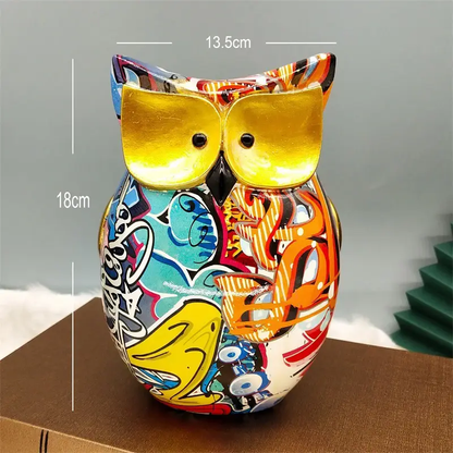 a colorful owl figurine sitting on top of a box