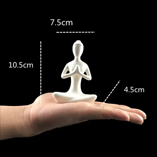 a hand holding a small white statue of a person