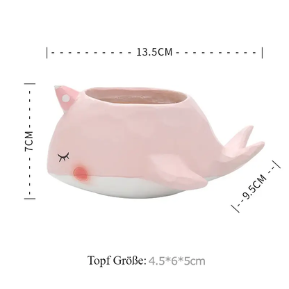 a pink whale shaped vase sitting on top of a table