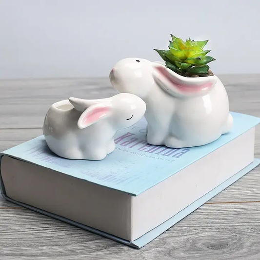 a couple of white elephants sitting on top of a book