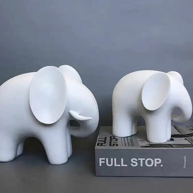 a couple of white elephants sitting on top of a box