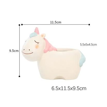 a white unicorn planter with a pink bow on it