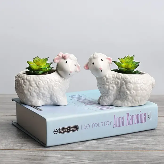 a couple of sheep sitting on top of a book
