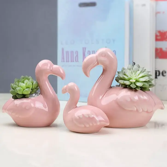 a couple of pink flamingos sitting on top of a table