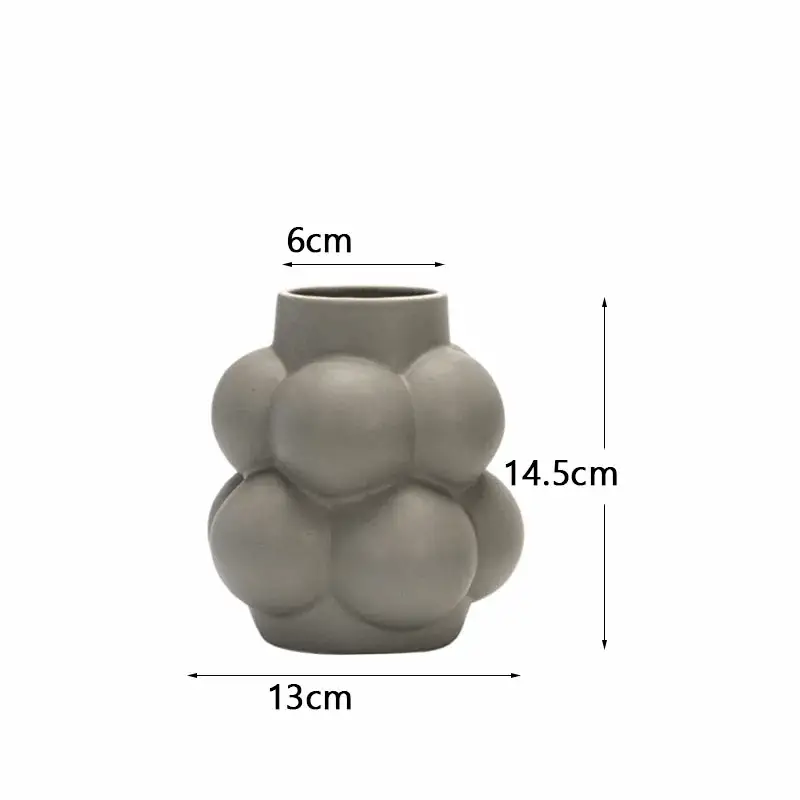 a gray vase with a large amount of balls on it