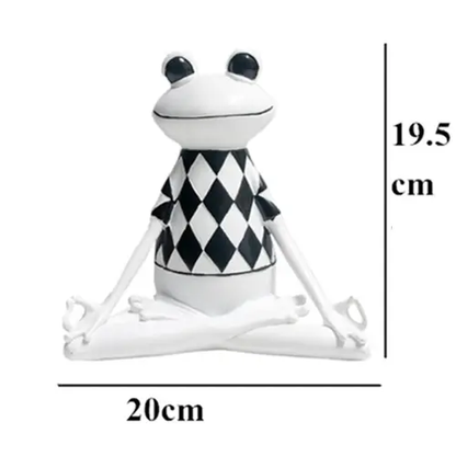 a white frog sitting on top of a black and white checkered cloth