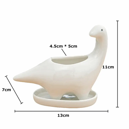 a white bird shaped vase sitting on top of a table