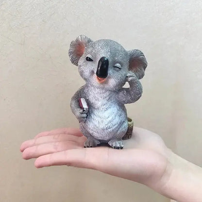 a small toy koala bear sitting on someone's hand