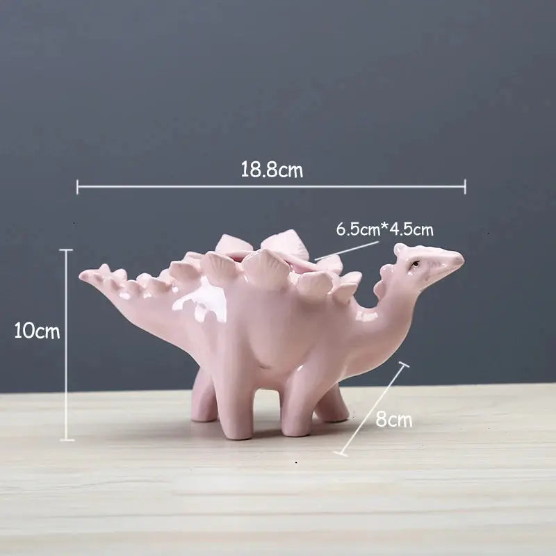 a pink dinosaur shaped vase sitting on top of a wooden table