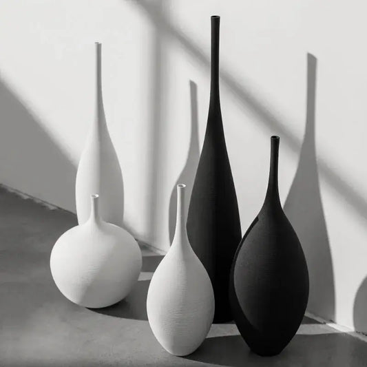 a black and white photo of three vases