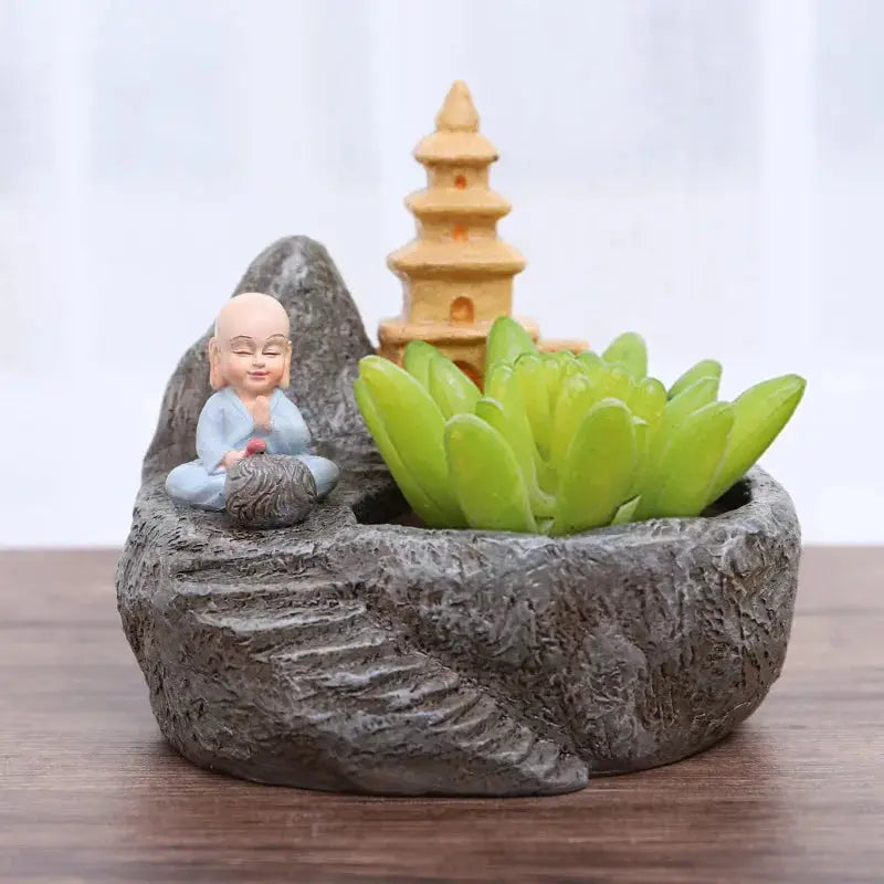 a small buddha statue sitting on top of a rock