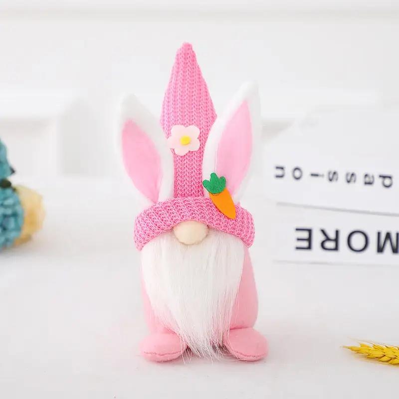 a pink knitted gnome with a carrot on its head