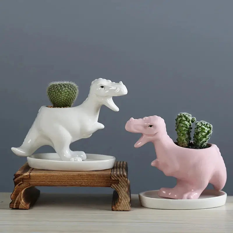 two ceramic dinosaurs in front of a cactus