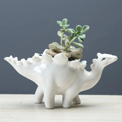 a white ceramic planter with a small plant in it