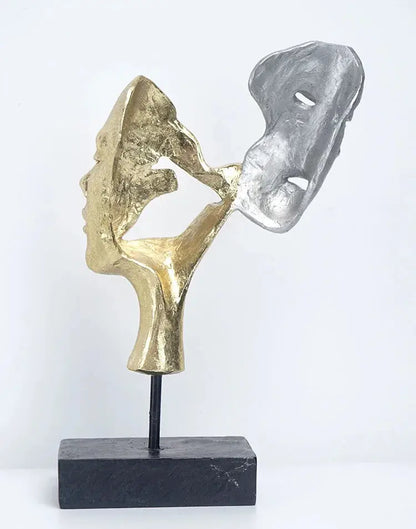 a gold and silver sculpture on a black stand