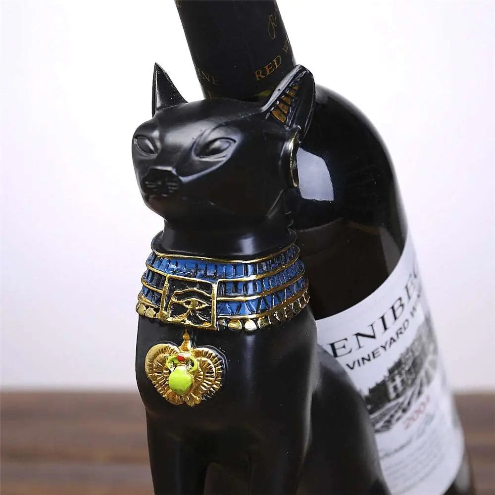 a bottle of wine with a cat figurine next to it