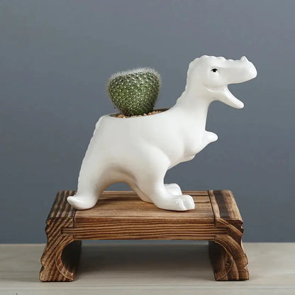 a small cactus sitting on top of a white ceramic animal