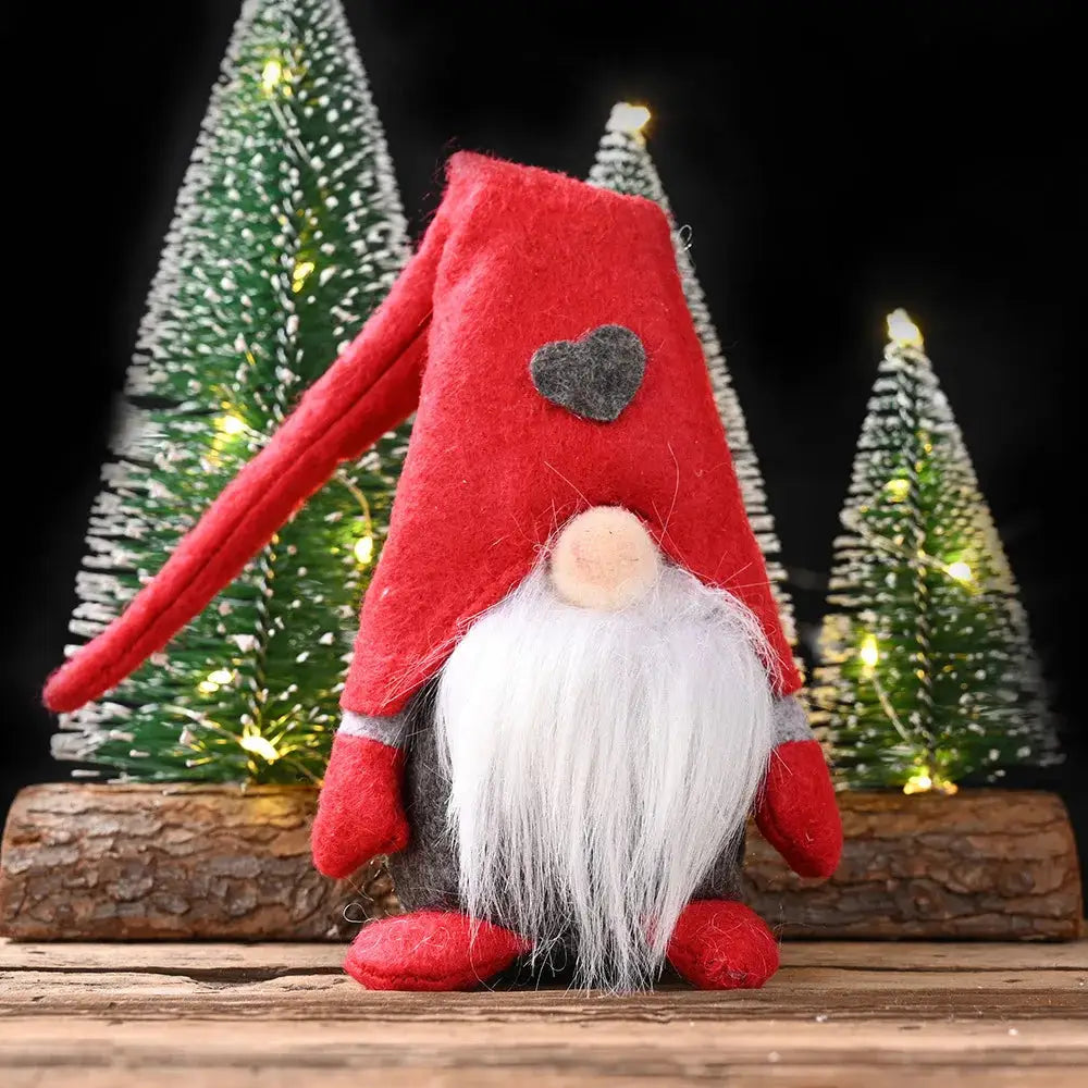 a red and white gnome sitting next to a christmas tree