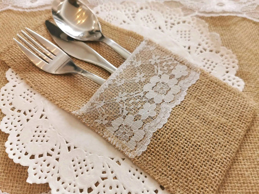 a place setting with silverware and a lace napkin