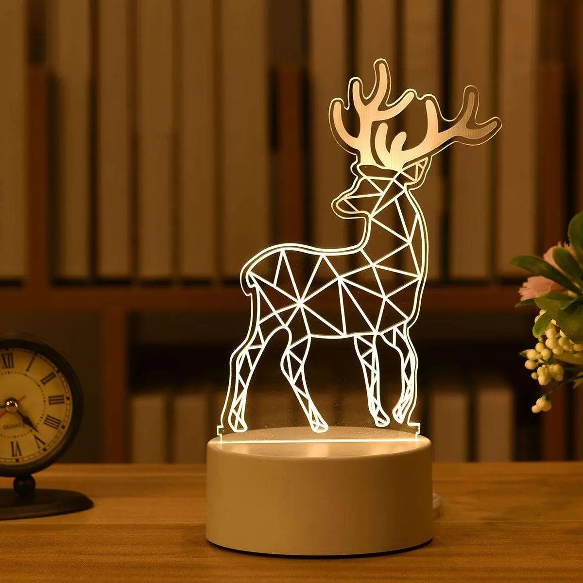 a light up deer on a table next to a clock
