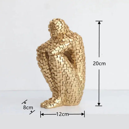 a golden figurine sitting on a white surface