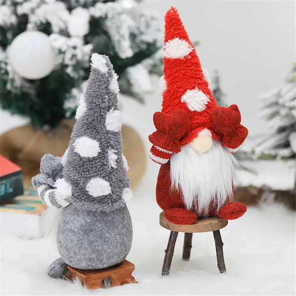 two gnomes sitting on a stool in the snow