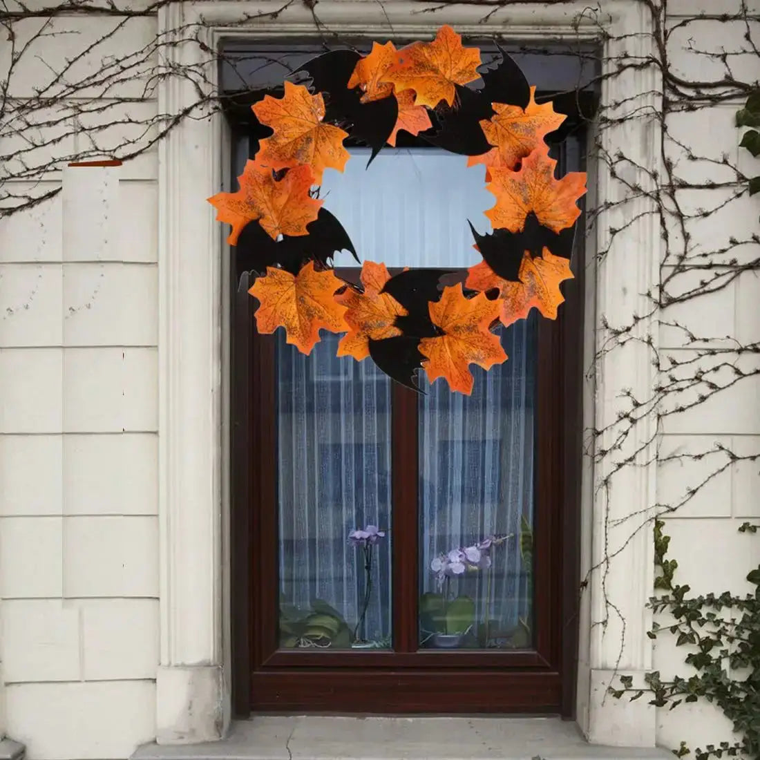 a wreath with orange leaves hanging from a window