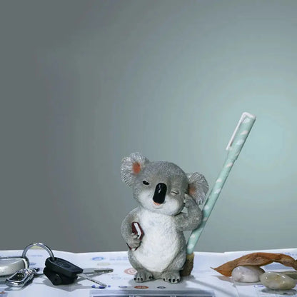 a stuffed koala holding a toothbrush on top of a table