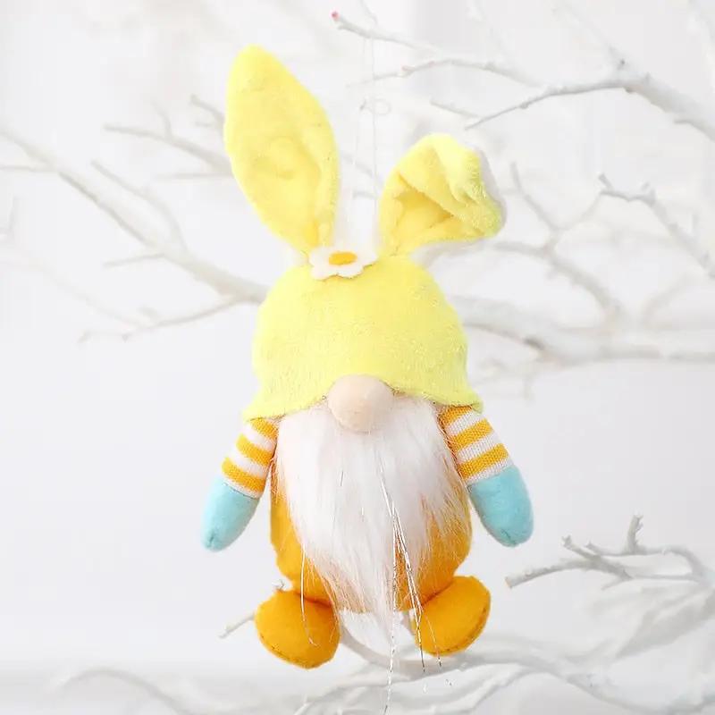 a yellow and blue stuffed animal hanging from a tree
