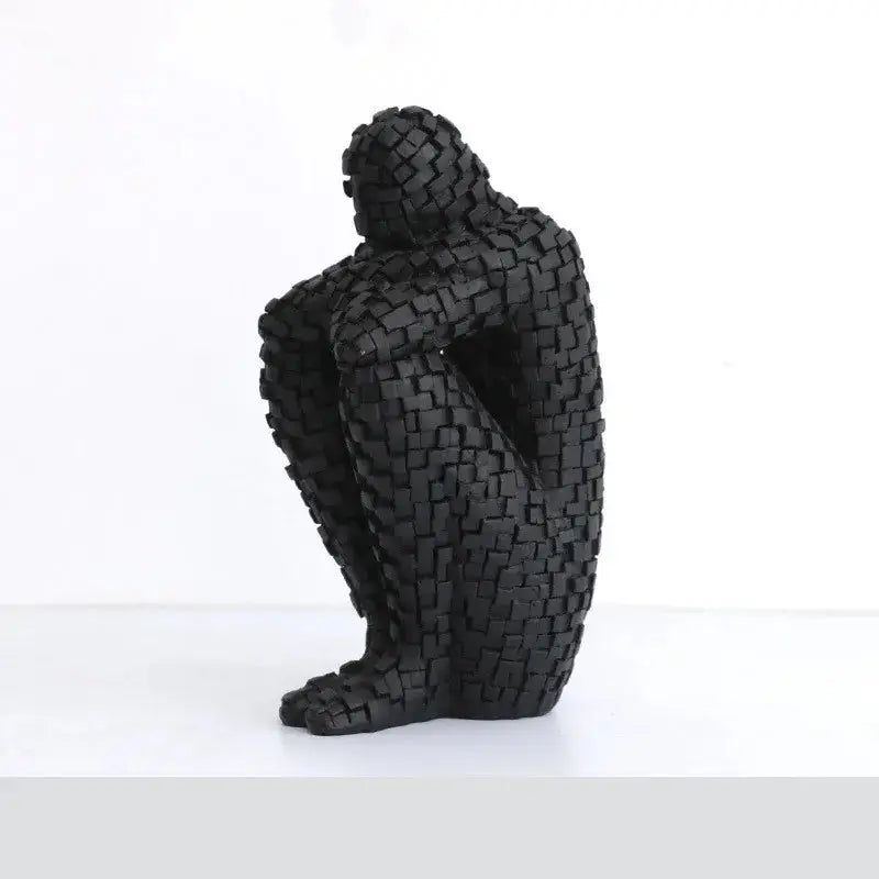 a sculpture of a person sitting on a white surface