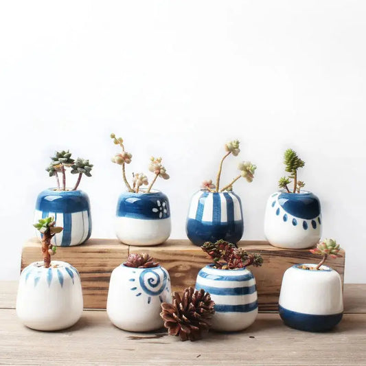 a group of blue and white vases sitting on top of a wooden table