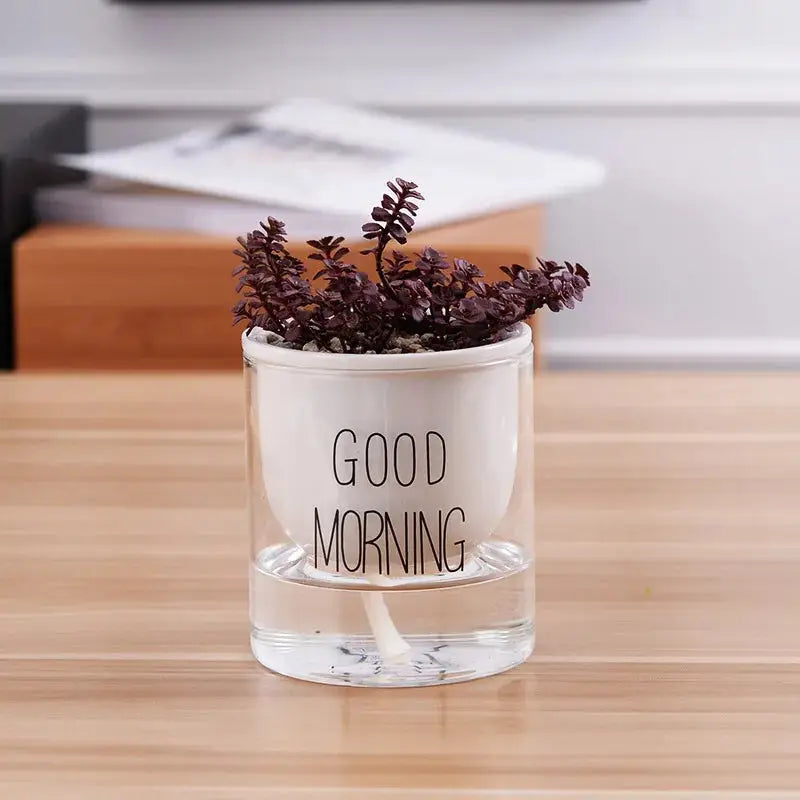 a glass vase with a plant in it that says good morning