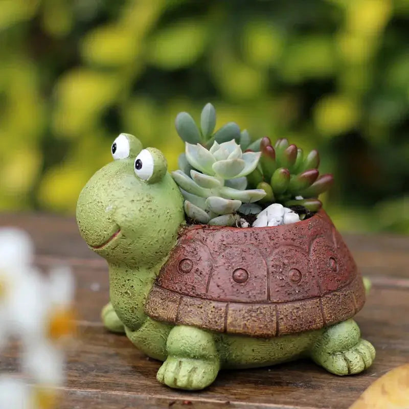 a small turtle planter with succulents in it