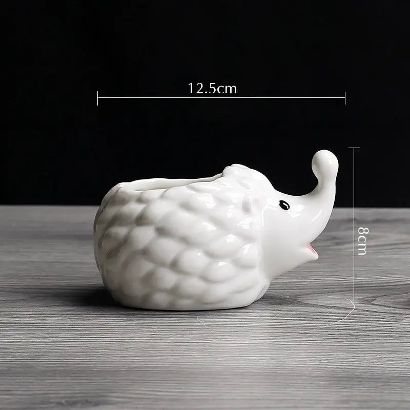 a white ceramic elephant figurine sitting on a table