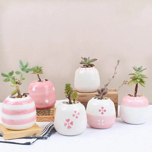 a group of ceramic planters sitting on top of a table