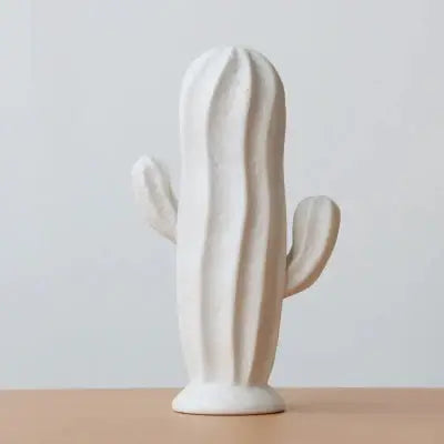 a white ceramic cactus sitting on top of a wooden table