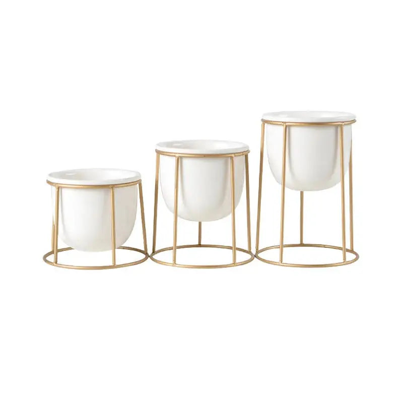 three white and gold planters on a white background
