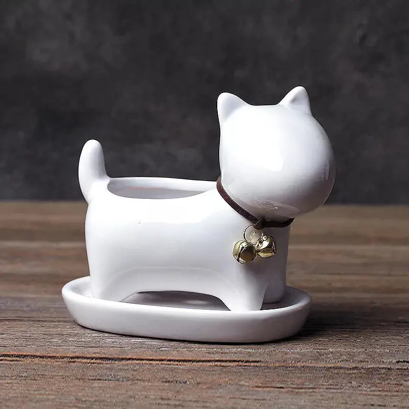 a white cat figurine sitting on a wooden table