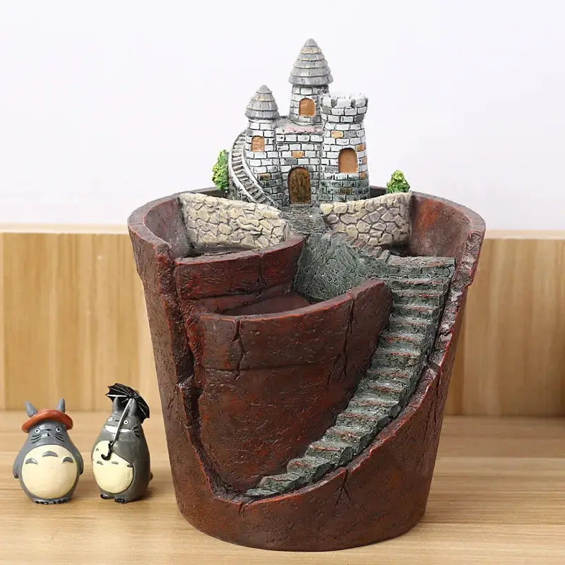 a statue of a castle on a table next to a small figurine