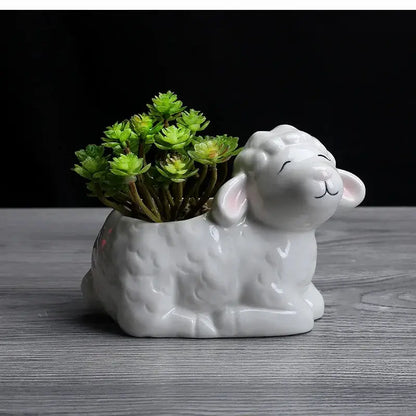 a ceramic sheep planter with a succulent in it