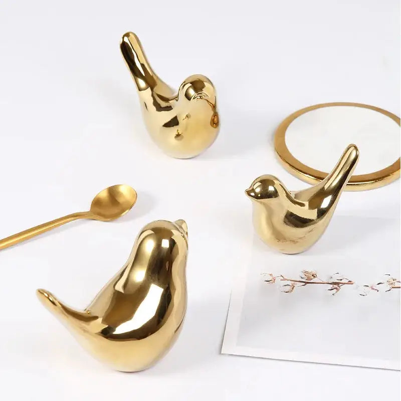 a set of three gold bird shaped objects