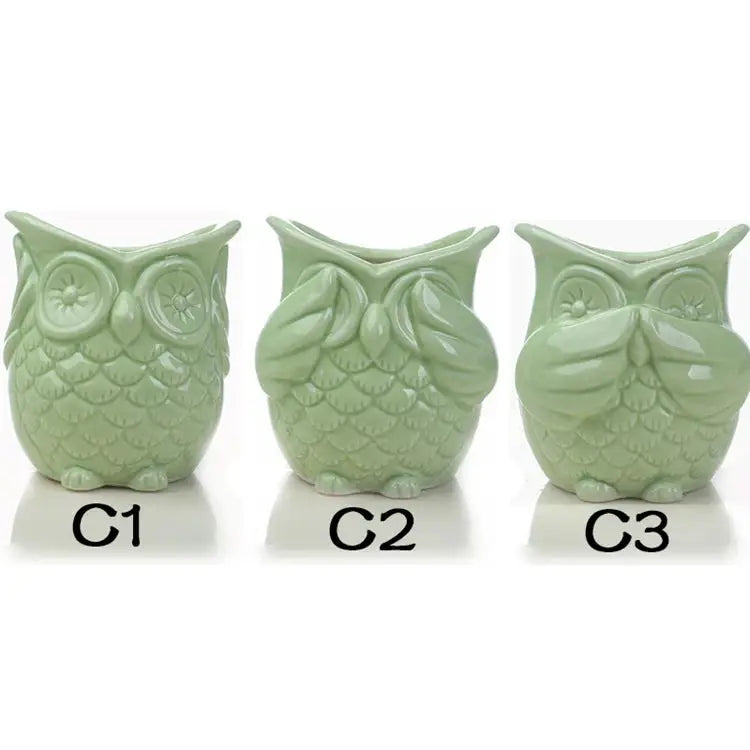 a set of three ceramic owls sitting next to each other