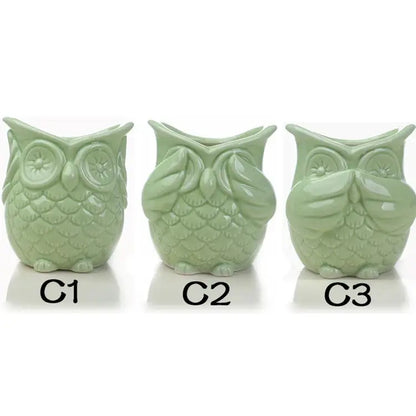 a set of three ceramic owls sitting next to each other