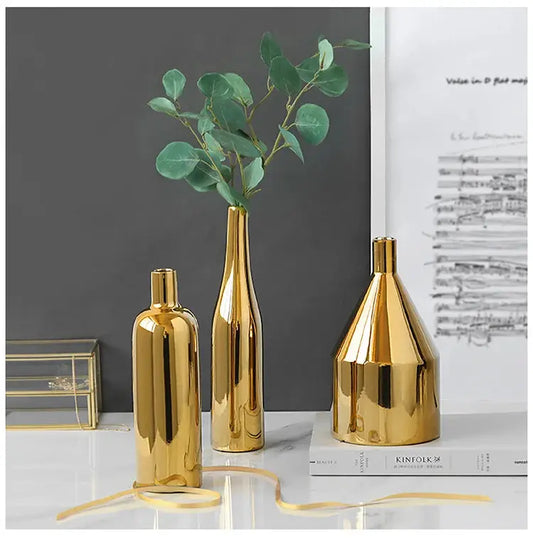 three gold vases with a plant in them
