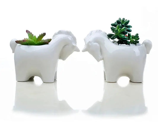 a couple of white elephant planters sitting next to each other