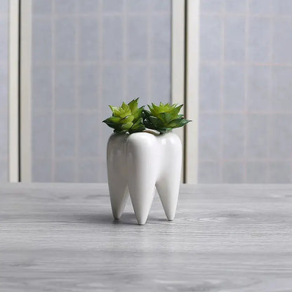 a tooth shaped vase with a plant in it