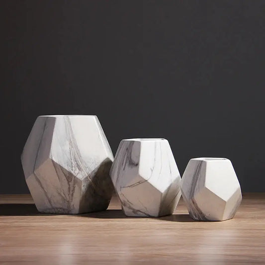 three marble vases sitting on top of a wooden table