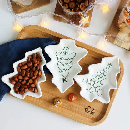 a wooden tray topped with three bowls filled with nuts